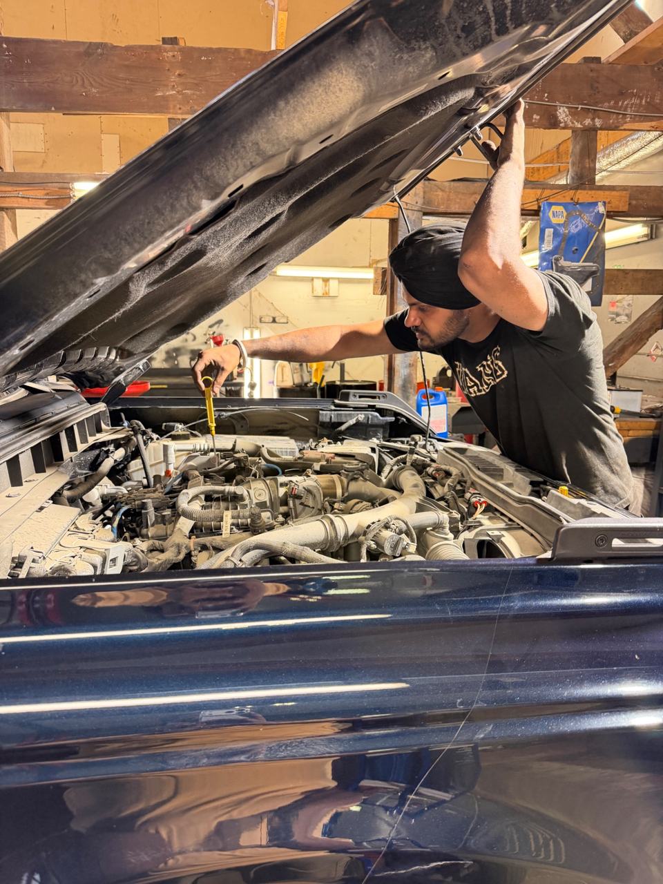 ABF technician using a dipstick to inspect an engine