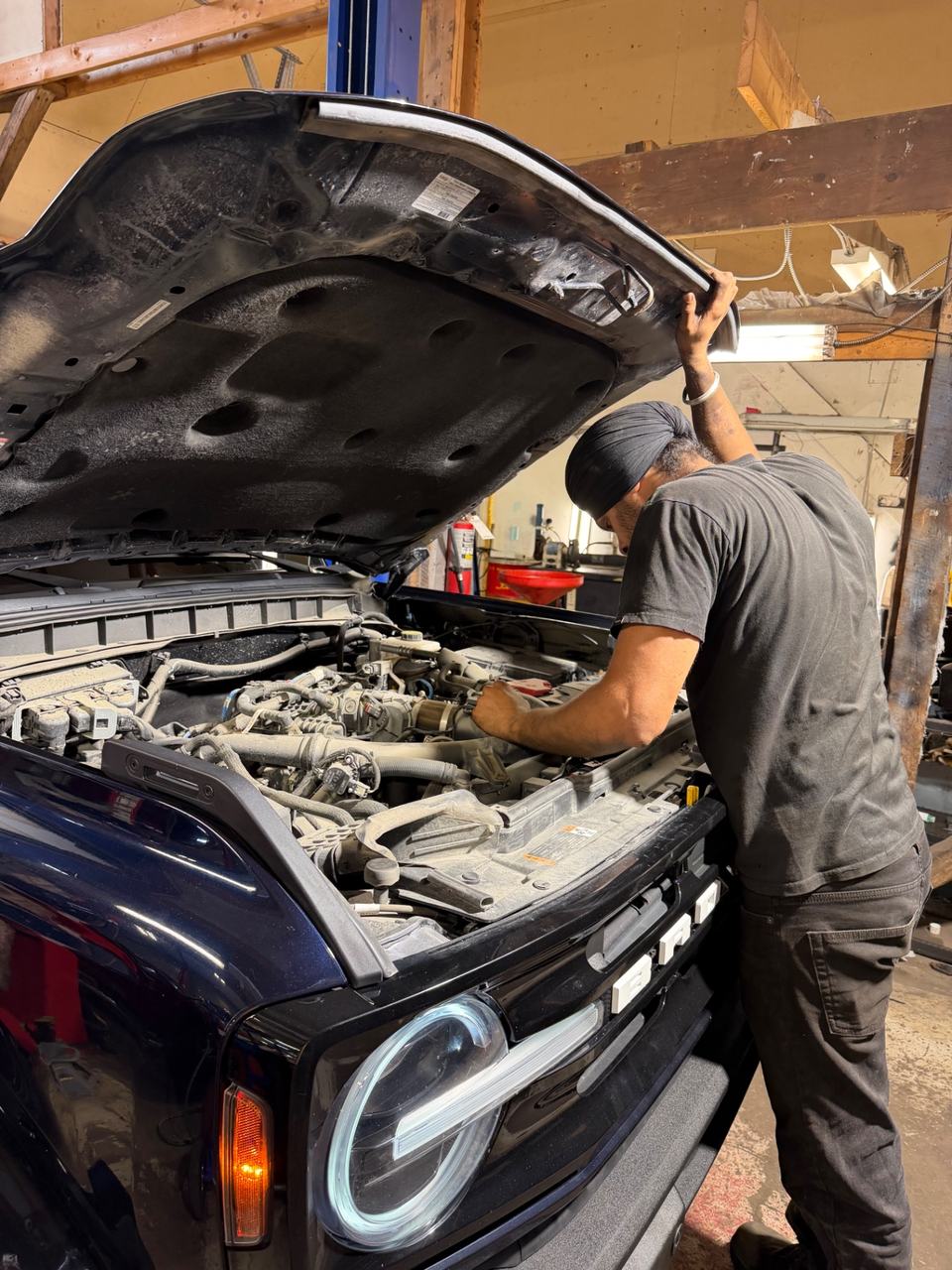 ABF technician inspecting a Ford Bronco engine bay